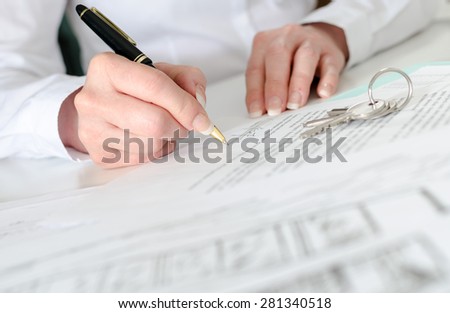 Client signing a real estate contract in real estate agency