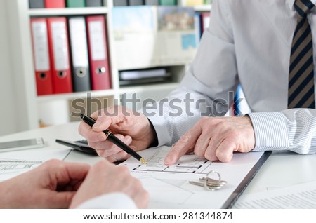 Realtor giving explanations to his client at the estate agency