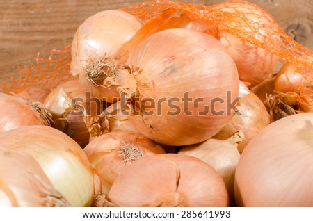 Fresh bulbs of onions on wooden background