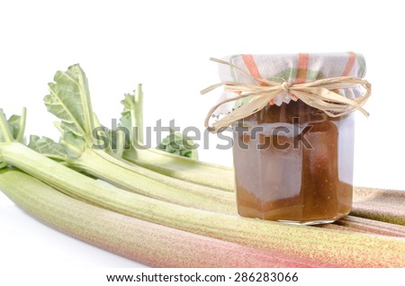 Rhubarb stalks with rhubarb jam jar, isolated on white