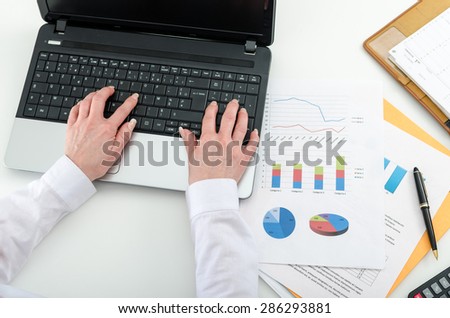 Businesswoman typing on a laptop, top view