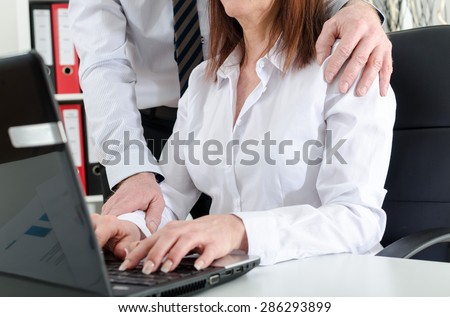 Manager putting his hand on the shoulder of his secretary, at the office
