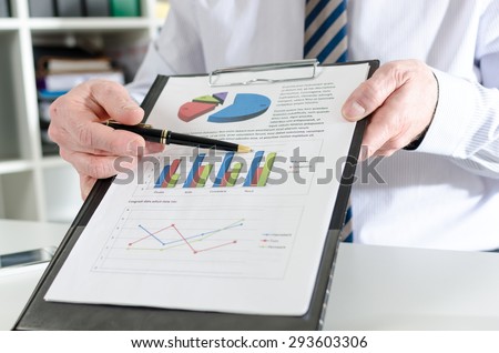 Businessman showing financial results on a clipboard