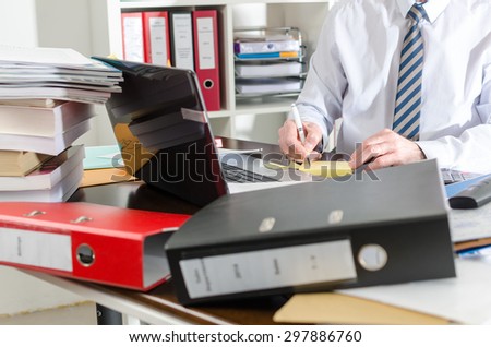 Businessman working at a untidy and cluttered desk