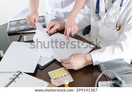 Doctors analyzing an electrocardiogram in medical office