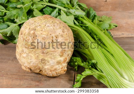 Celery root and green celery on wooden background