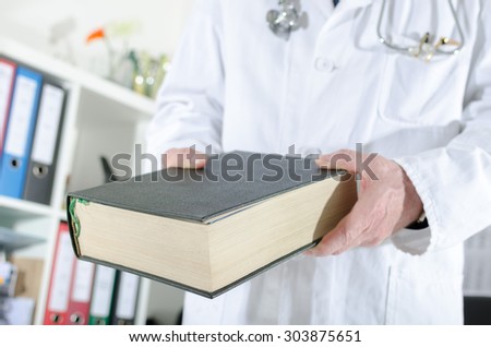 Doctor holding a medical book at office