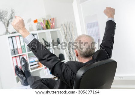 Businessman stretching his arms at office
