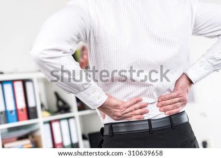 Businessman suffering from back pain at office