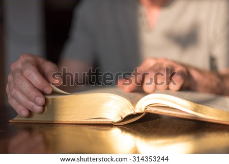 Man reading the Bible in dim light