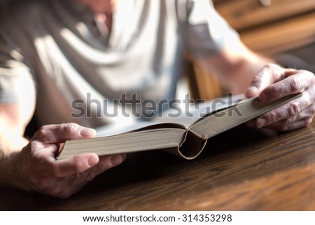 Man sitting at a table reading a book