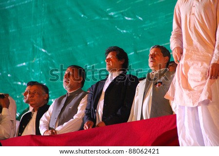 LAHORE, PAKISTAN - OCT 30: Chairman Pakistan Tehreek-e-Insaf Imran Khan with other PTI leaders standing for national anthem during a political rally on October 30, 2011 in Lahore, Pakistan