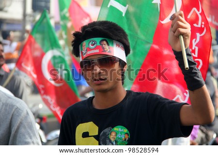 SIALKOT, PAKISTAN - MAR 23: Young supporter of PTI at Jinnah Cricket Stadium during a political rally of cricketer turned politician Imran Khan on March 23, 2012 in Sialkot, Pakistan