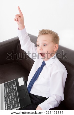 Boy sitting with the computer in shirt have idea.Eureka