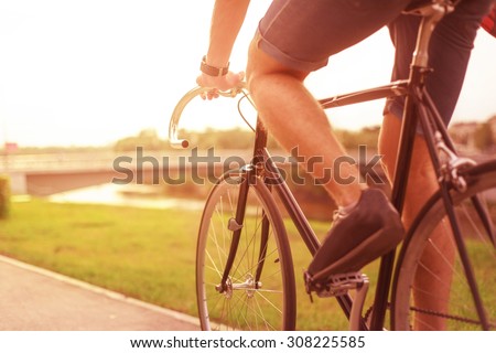 Hipster on bike in the city at sunset. Without face