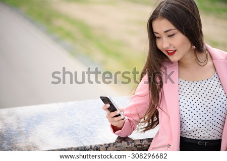 Smiling asian woman looking at phone. Copyspace