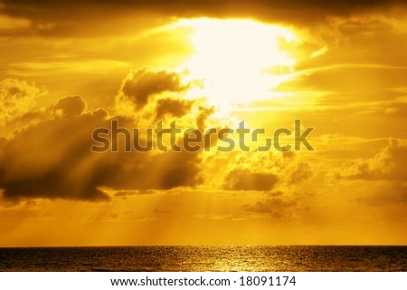 Golden sunlight through clouds on the sea