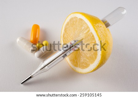 Lemon, pills ,  vitamins with thermometer isolated  on white background