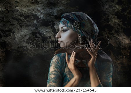 beautiful mysterious girl with a lamp in a dark cave
