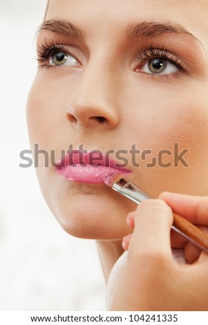grooming eyebrows with eyebrow brush - professional makeup artist working