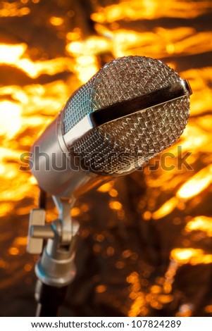 close up of microphone on the stand on golden background