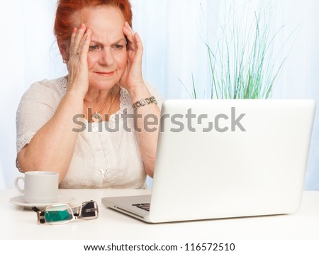 Senior woman with confused expression on her face sitting behind her laptop