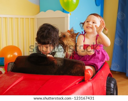 Kids with dog play in the toy car