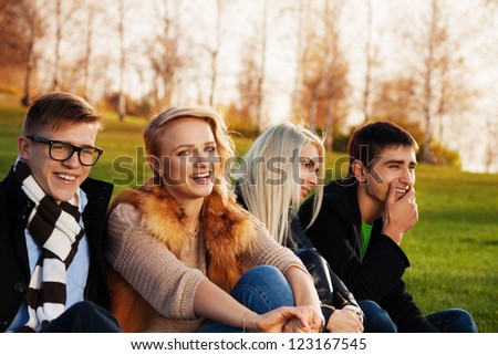 Four cute students hanging out in the park and having fun