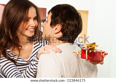 Happy woman with amazing smile giving small box present to her boyfriend