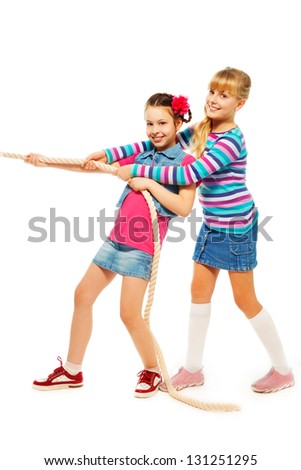 Two 9-10 years old girls pulling the rope in team standing isolated on white