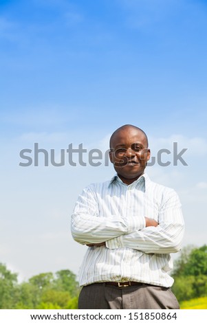 Happy confident black man wearing shirt outside in the park