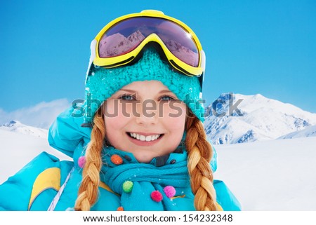 Close poortrait of a snowboard girl with mountain peaks on background