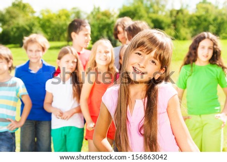 Happy group of people and close portrait one Caucasian girl in red shirt