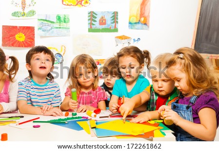Group Of Little Kids Painting With Pencils And Gluing With Glue Stick On Art Class In Kindergarten