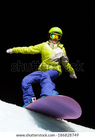Girl ready to slide with snowboard at night