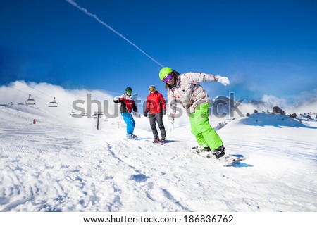 Guys and one man snowboarding downhill