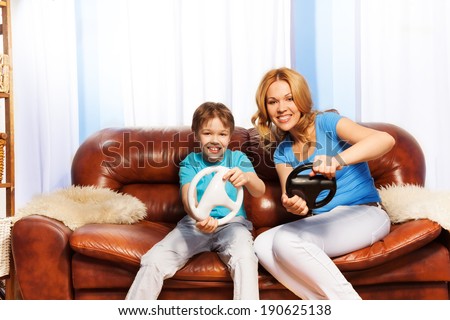 Mother and child driving with steering wheels