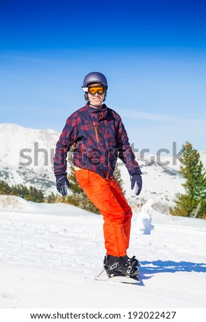 Man in ski mask standing on the snowboard