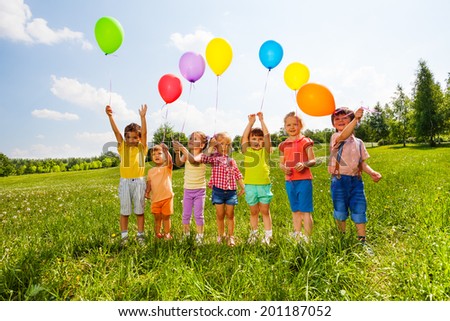 Seven children with balloons in green field Seven children with balloons in green field