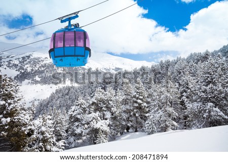 Closeup of ski lift cable car and forest covered with snow on the background
