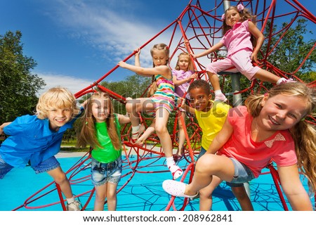 Happy group of kids on red ropes together in park