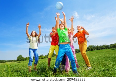 Happy kids catching ball in air outside