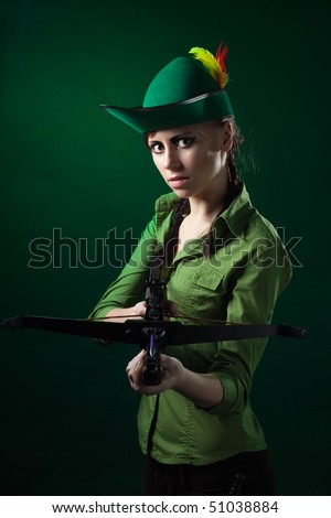Serious woman frowning holding crossbow and aiming