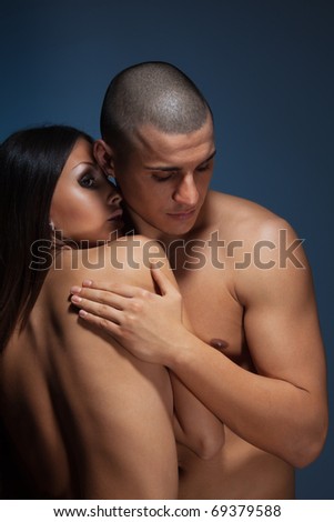 Naked couple with man snuggle up girlfriend on dark background
