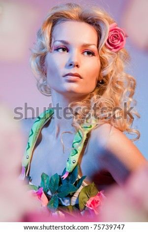 stock photo : Portrait of a woman in flowers depicting bible woman Eva with snake on her neck