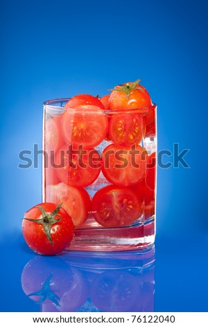 Tomato juice allegory with small cherry tomato on the table