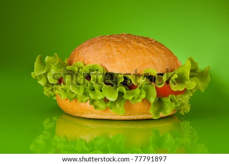 Healthy hamburger without meat only with tomatoes and salad on green background