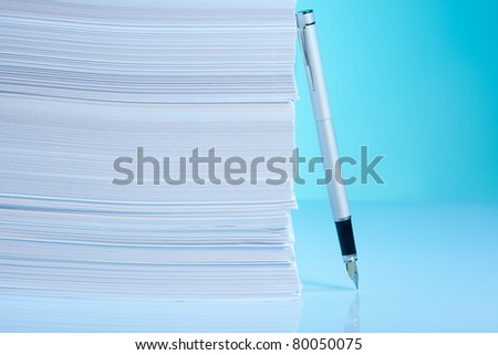 Paper pile and pen on blue background - business concept