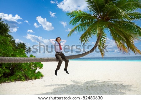 Happy businessman in formal clothes and tie sitting on the palm and relax