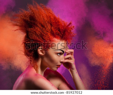 Beauty portrait of woman with color explosion made of color powder